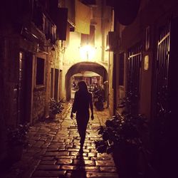 Woman standing on street at night