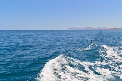 Waves with foam in the open space of the blue aegean sea in crete, greece.