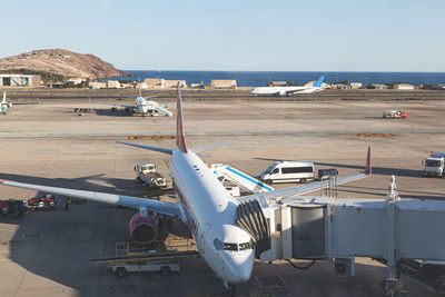 Airplane on airport runway against sky