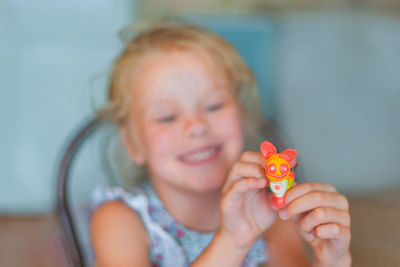 Portrait of smiling girl holding eyeglasses