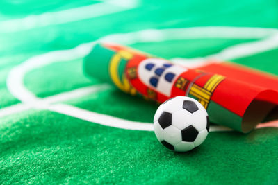 Close-up of small soccer ball with flag on green textile