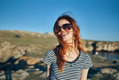 Mid adult man wearing sunglasses standing against sky