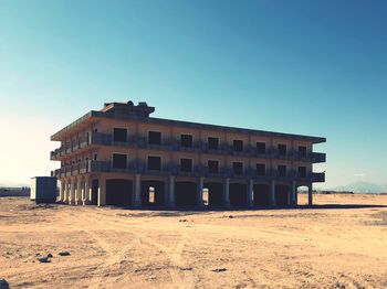 Building on beach against clear blue sky