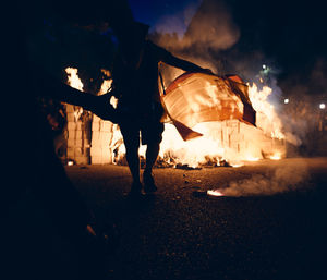 Low angle view of people photographing against sky at night