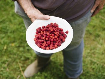 Woman holding bowl with japanese wineberries