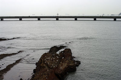 Bridge over sea against clear sky