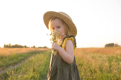 Girl standing on field against sky