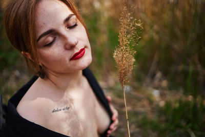 Close-up of young sexy woman with eyes closed in field