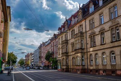 Street by buildings against sky in city