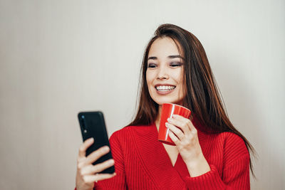 Portrait of a smiling young woman using mobile phone