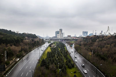 Cars on road in city against sky