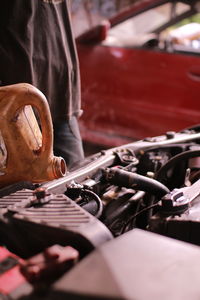 Close-up of man oiling car