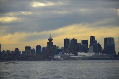 Modern buildings in vancouver against cloudy sky at sunset