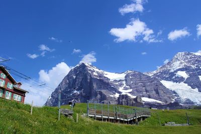 Scenic view of field and mountains against blue sky