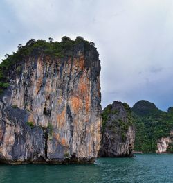 Rock formations by sea against sky