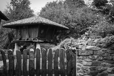 Hut on field against trees