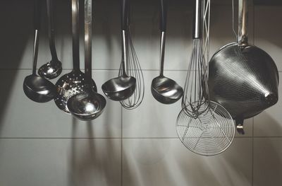 Utensils hanging against wall in kitchen at home