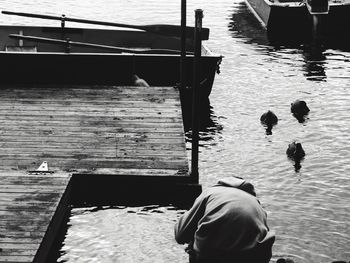 Rear view of man on boat at harbor