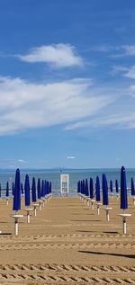 Wooden posts on beach against sky