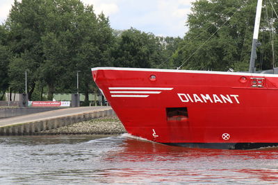 Red boat in river against sky