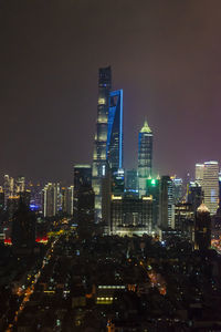 Illuminated buildings in city against sky at night