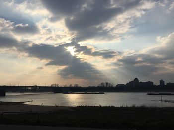 Scenic view of river against cloudy sky