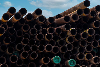 Stack of pipes against sky