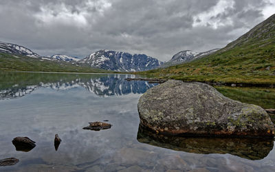 Scenic view of lake by mountain against sky