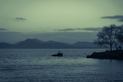 Silhouette boat in sea against sky
