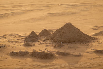 Scenic view of desert land against sky during sunset