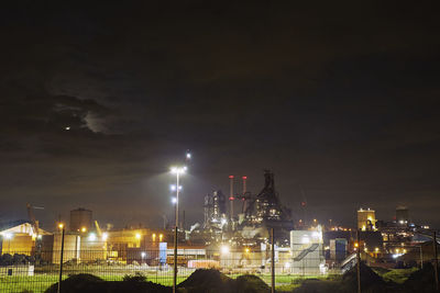 Illuminated cityscape against sky at night