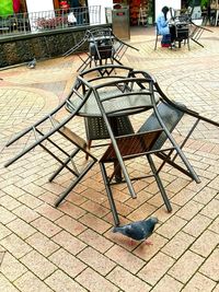 Empty chairs and tables in sidewalk cafe