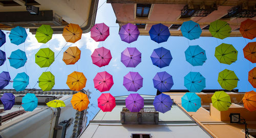 Multi colored umbrellas hanging on wall in market