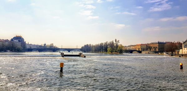 Scenic view of river against sky in city