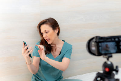 Portrait of woman photographing with mobile phone