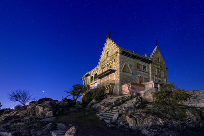 Low angle view of building against blue sky at night