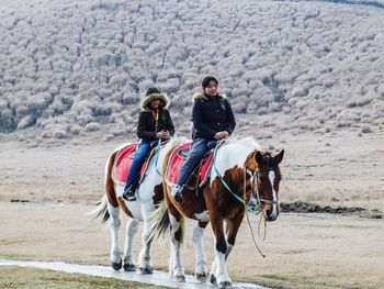 Full length of horse riding