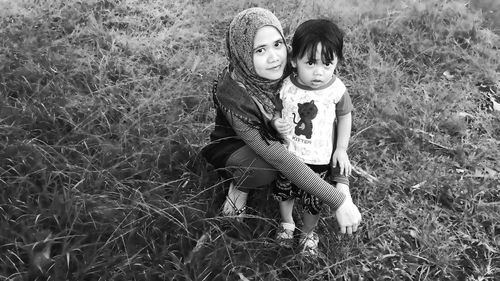 Portrait of mother and daughter on field