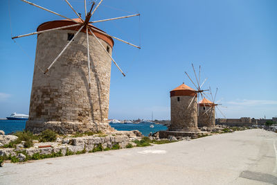 Old windmills at mandraki harbour in rhodes city on rhodes island, greece
