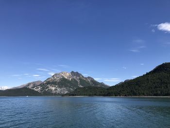 Scenic view of lake and mountains against blue sky