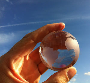 Low angle view of cropped hand against clear sky