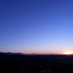 Scenic view of landscape against clear sky at sunset