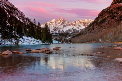 Scenic view of lake by snowcapped mountains against sky during winter