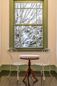 Empty chairs and table against window at home