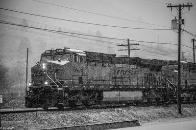 Train on railroad tracks against sky during winter