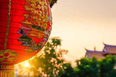 Close-up of illuminated lantern against sky at sunset