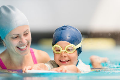 Mother assisting son in swimming at pool