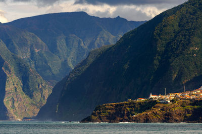 Scenic view of sea and mountains against sky