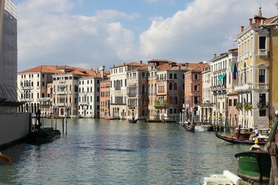 Canal amidst buildings against sky