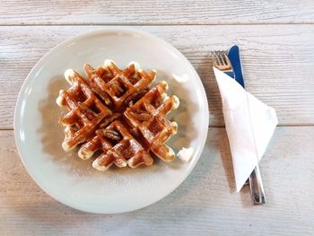 Belgian waffle with syrup on plate